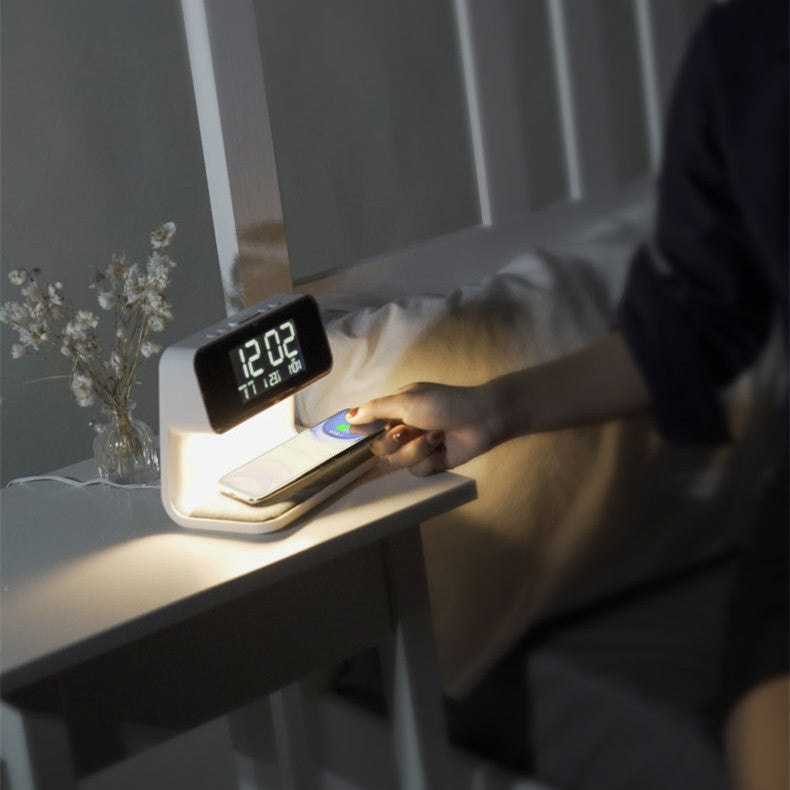 Detail van telefoon die draadloos oplaadt op de basis van de 3-in-1 LED tafellamp met wekker.