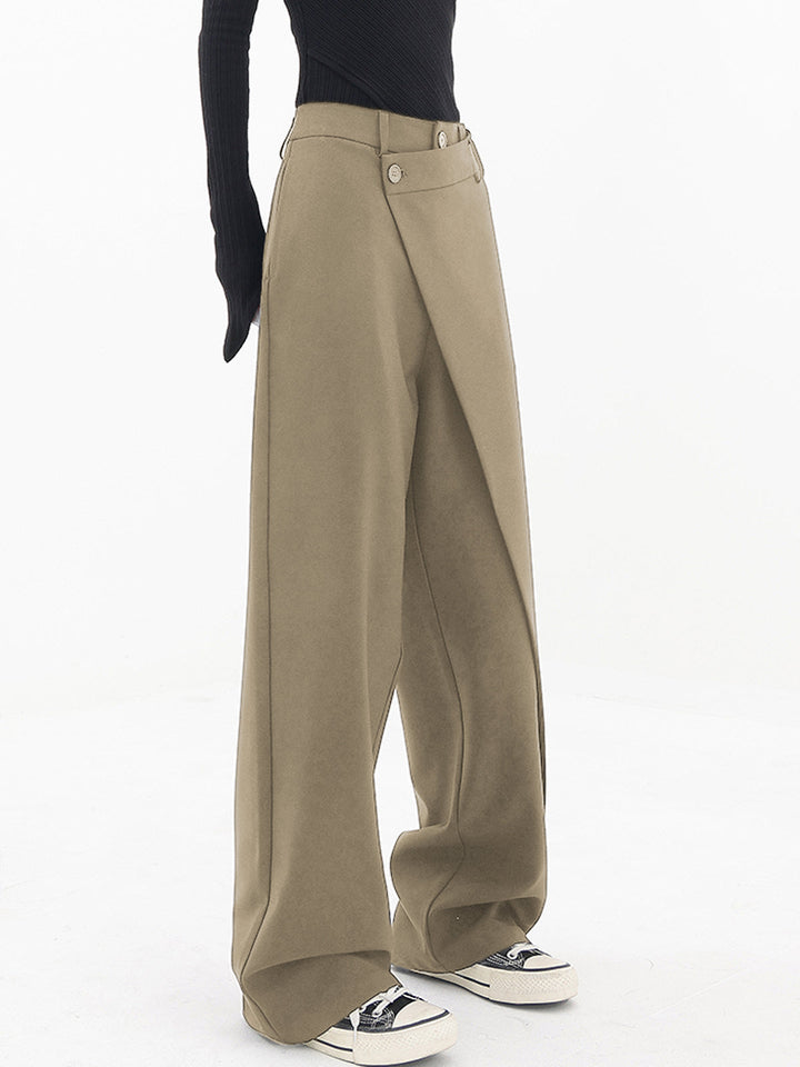 Vrouw draagt trendy Noa asymmetrische wijde broek met dubbele knoop, benadrukt de relaxte en stijlvolle pasvorm.