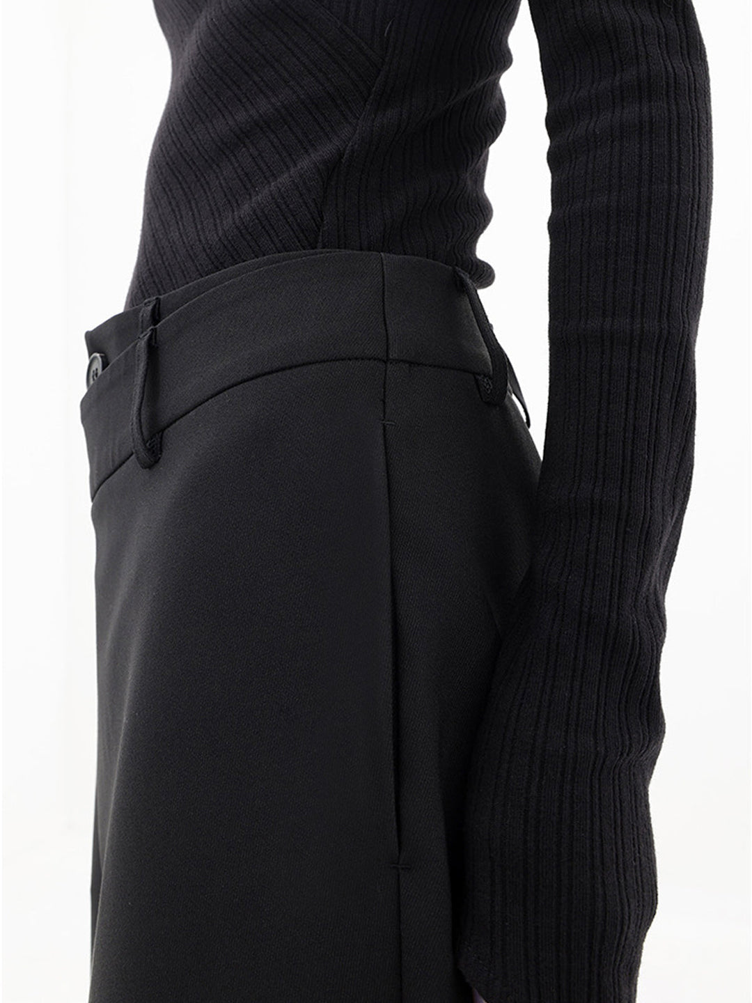 Close-up van de dubbele knoop en asymmetrische taille van de trendy wijde damesbroek Noa.