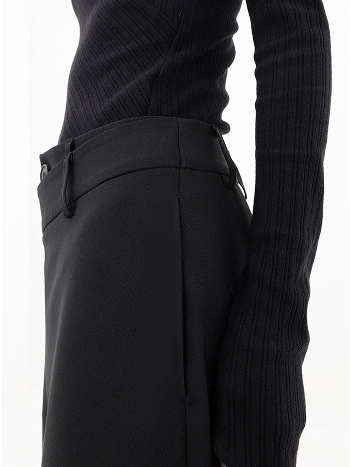 Close-up van de dubbele knoop en asymmetrische taille van de trendy wijde damesbroek Noa.