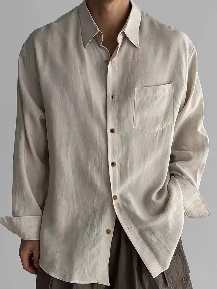 Man draagt beige casual V-hals overhemd met lange mouwen. Ontspannen zomerstijl, perfect voor strand of terras.