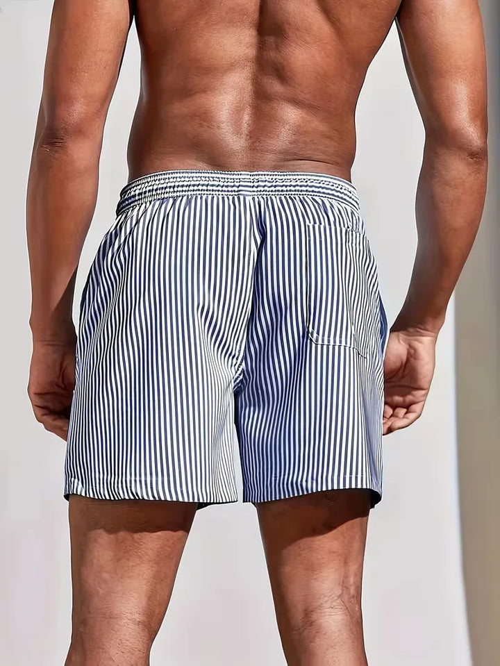 Comfortabele heren zwemshorts met blauwe en roze strepen, geschikt voor zwemmen en ontspannen aan het strand.