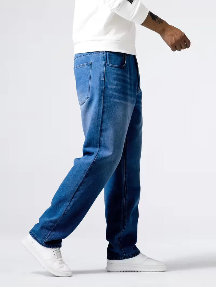 Model draagt stijlvolle blauwe heren loose fit jeans, perfect voor een casual look met comfortabele pasvorm.