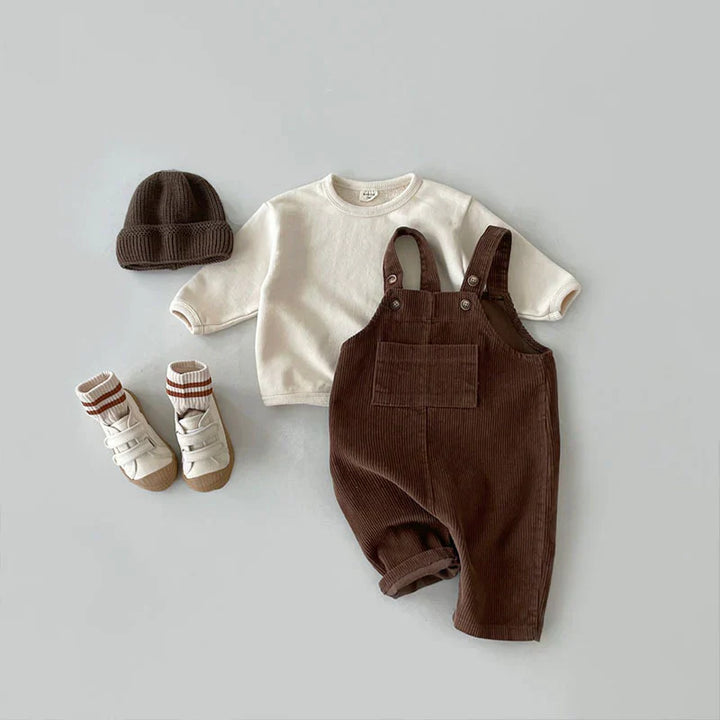 Comfortabele kinderoverall van duurzame stof, bruin, met verstelbare schouderbanden.