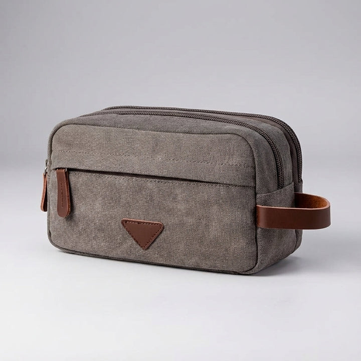 Compacte canvas toilettas, geschikt voor reizen of dagelijks gebruik, met slim dubbel compartiment ontwerp.