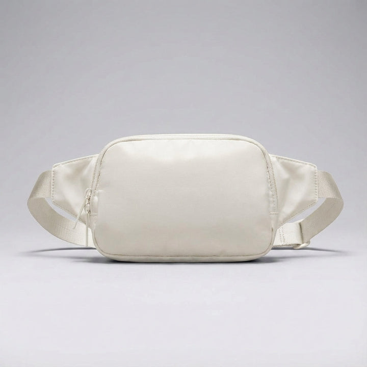 Gedetailleerde compacte heuptas van nylon met ritsvakken en verstelbare band, perfecte reisaccessoire.