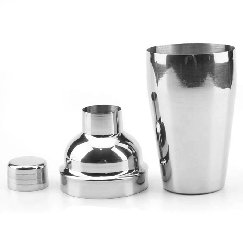 Complete cocktailshaker set met roestvrijstalen accessoires en houten standaard, ideaal voor thuisbars en bartenders.