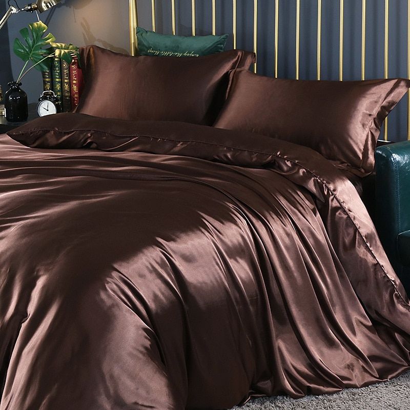 Zijden beddengoedset op een bed, met kussens en dekbed, voor een complete en luxe slaapervaring.