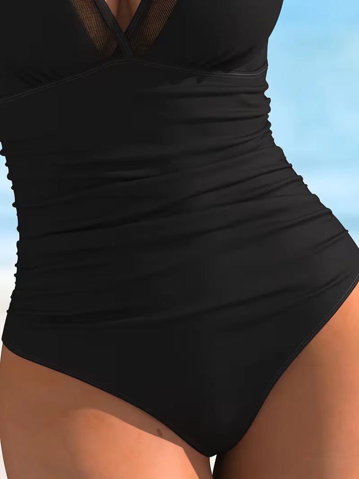 Stijlvol dames badpak met V-hals, fijne mesh details en slimme pasvorm. Essentiële badmode voor de zomer.