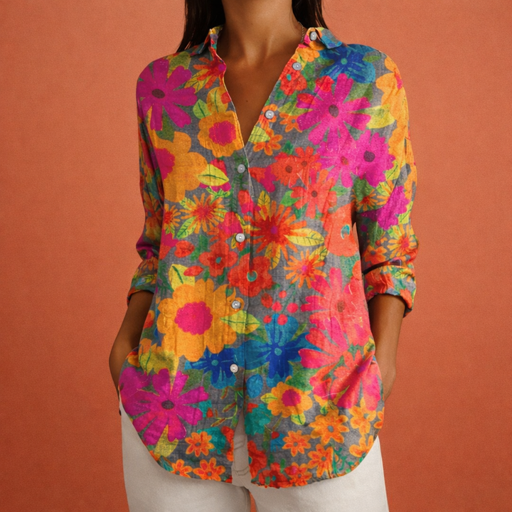 Model draagt bedrukte damesblouse met klassieke kraag en lange mouwen. Elegantie en comfort in één kledingstuk.
