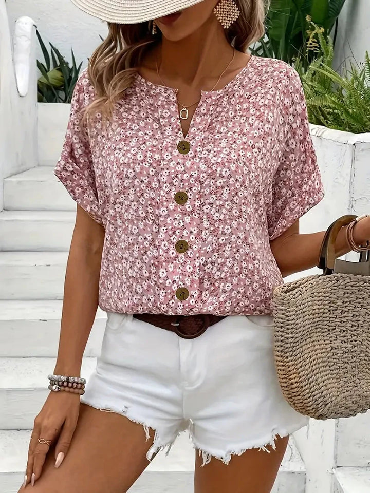 Casual dames blouse met vrouwelijke bloemenprint, perfect voor de zomer. Roze korte mouw blouse met ronde hals.