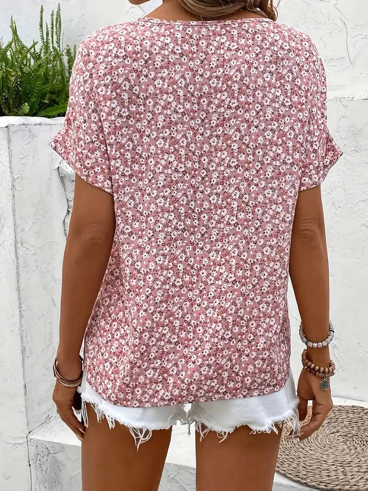 Losvallende dames blouse met fleurige bloemenprint. Korte mouw zomerblouse met ronde hals en knoopsluiting.