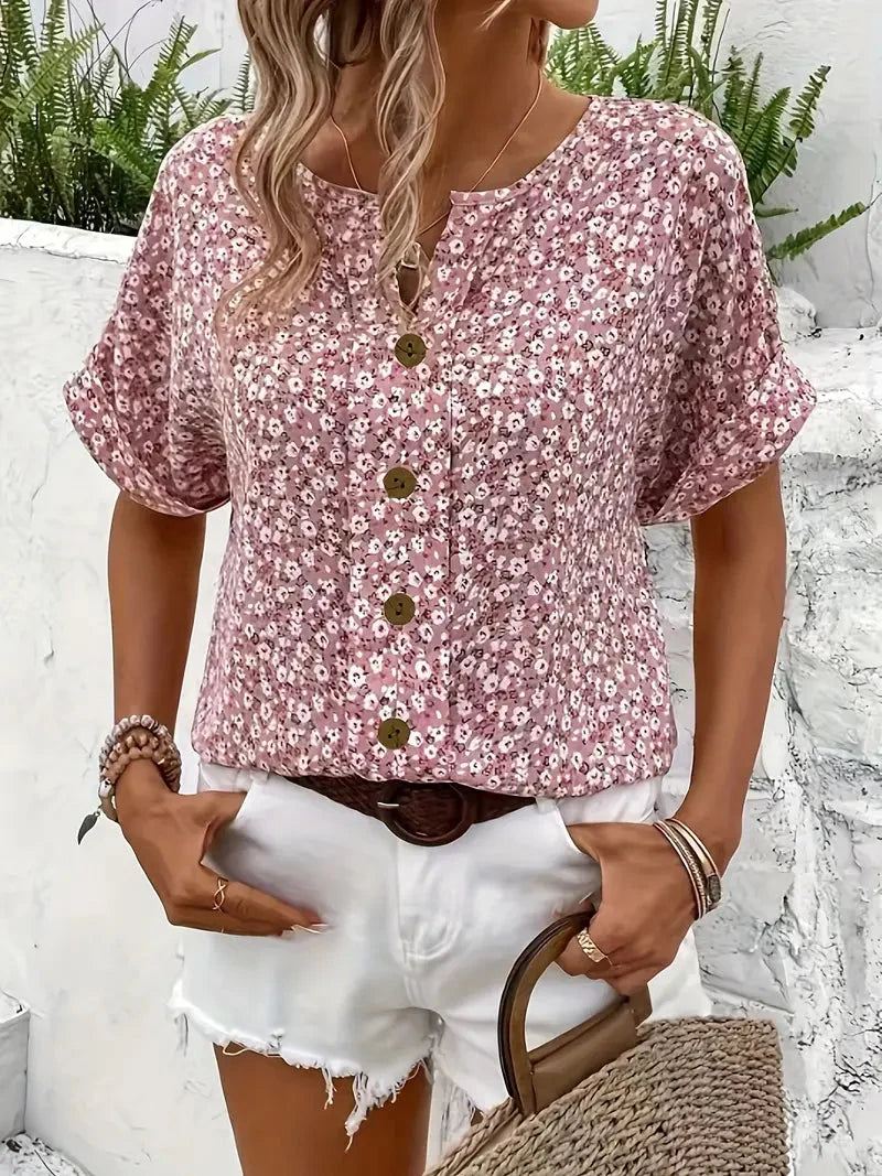 Roze dames blouse met vrolijke bloemenprint en korte mouwen. Comfortabele loose fit blouse met ronde hals.