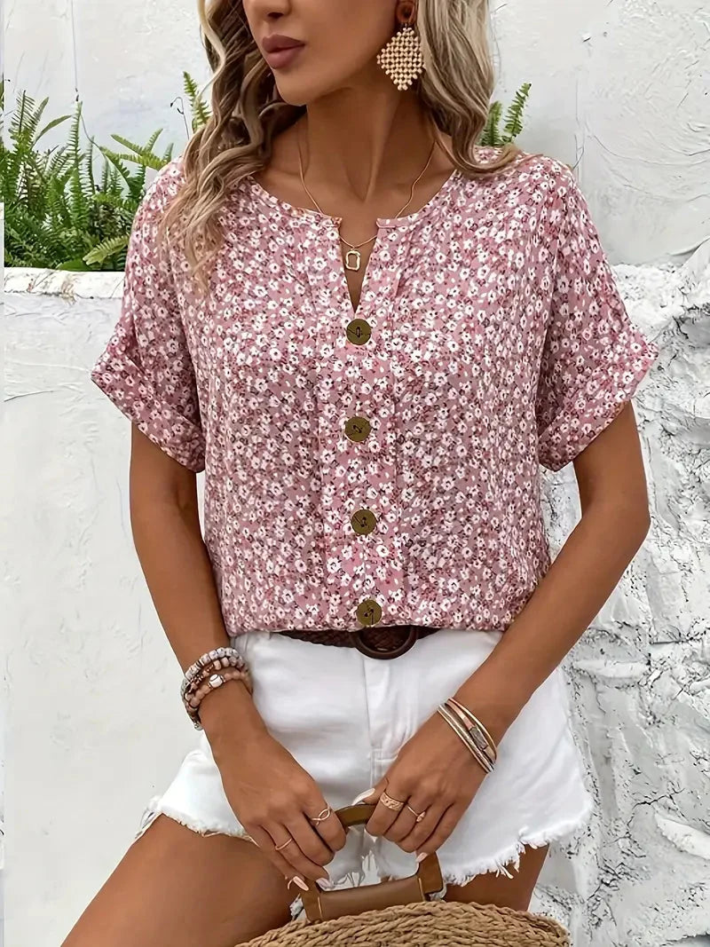 Modieuze dames blouse met bloemenprint, korte mouw en ronde hals. Zomerse roze loose fit blouse met knopen.