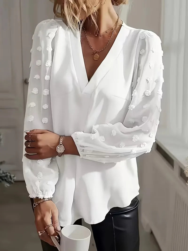 Modieuze damesblouse met diepe V-hals en elegante doorschijnende mouwen.