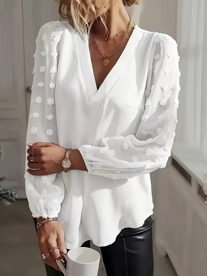 Modieuze damesblouse met diepe V-hals en elegante doorschijnende mouwen.