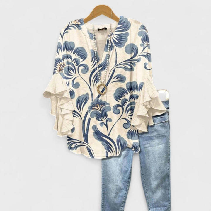 Vrouwelijke damesblouse met diepe V-hals, wijde volantmouwen en een comfortabele oversized pasvorm.