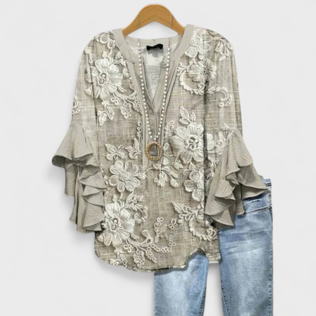 Damesblouse met verfijnde V-hals, volumineuze volantmouwen en een moderne, vrouwelijke uitstraling.