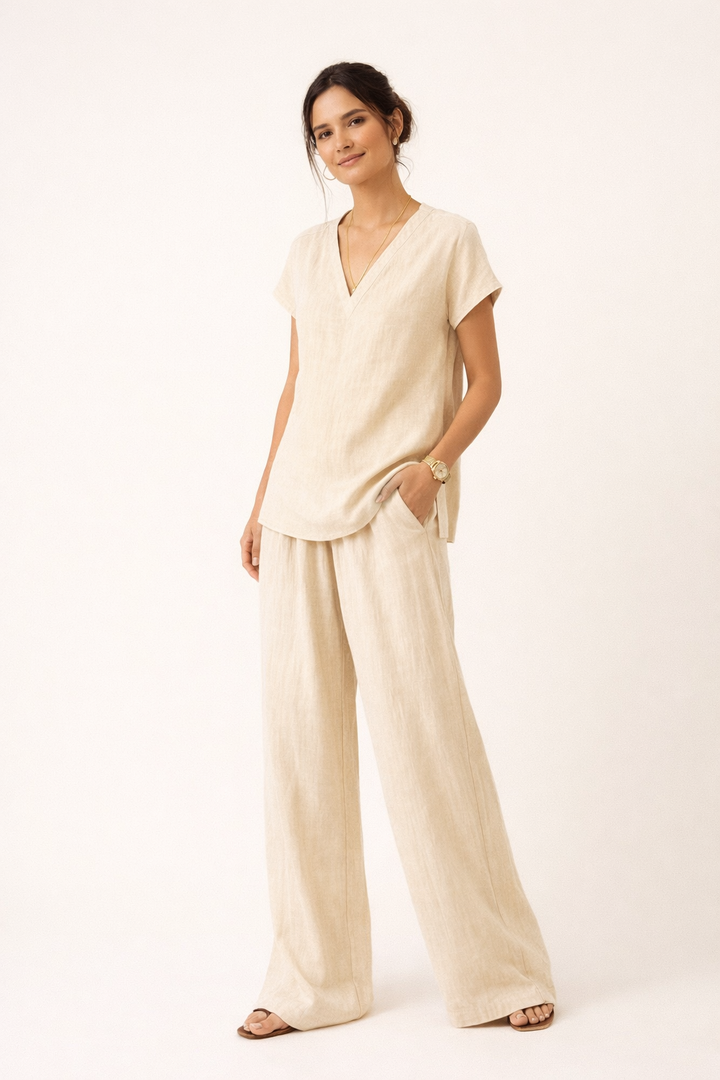 Model draagt losse linnen tweedelige set voor dames, met V-hals top en wijde broek, ideaal voor de zomer.