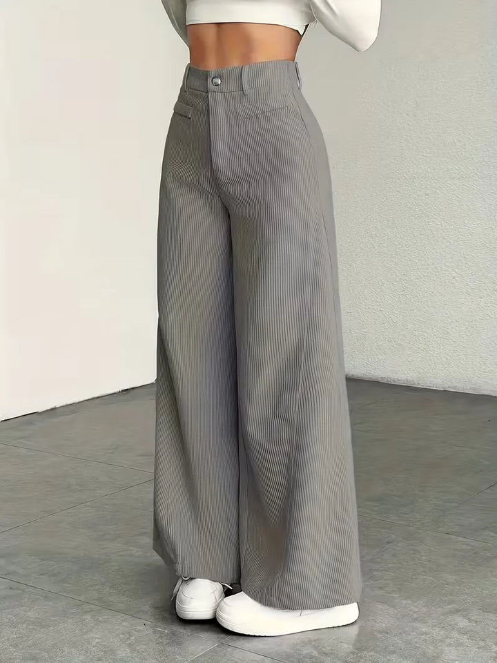 Model draagt een elegante wide leg damesbroek met hoge taille en corduroy.