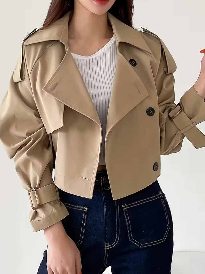 Khaki dames cropped trenchcoat met dubbele knopen. Stijlvolle korte jas voor lente/herfst mode. Dameskleding.