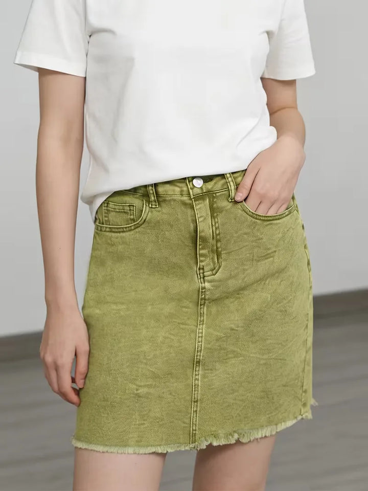 Zomerse matcha groene denim minirok, hoge taille, vervaagd effect, streetwear mode.