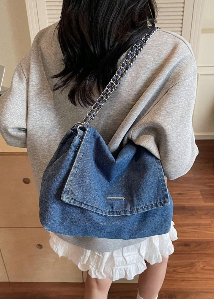 Textuur van de spijkerstof denim schoudertas, elegant gecombineerd met metallic ketting.