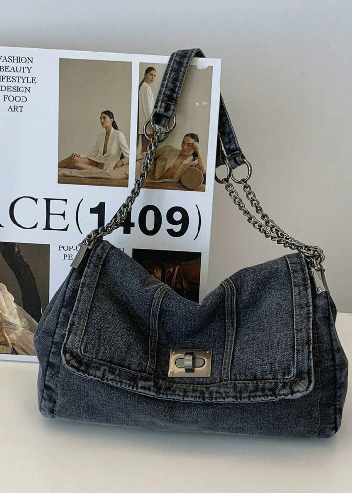 Trendy blauwe denim schoudertas voor dames, verfraaid met een chic metallic ketting.