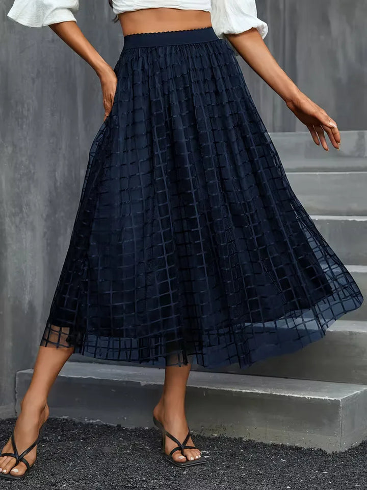 Dames elegante plooirok marineblauw met klassiek ruitpatroon. Perfecte midi-lengte voor lente/zomer.