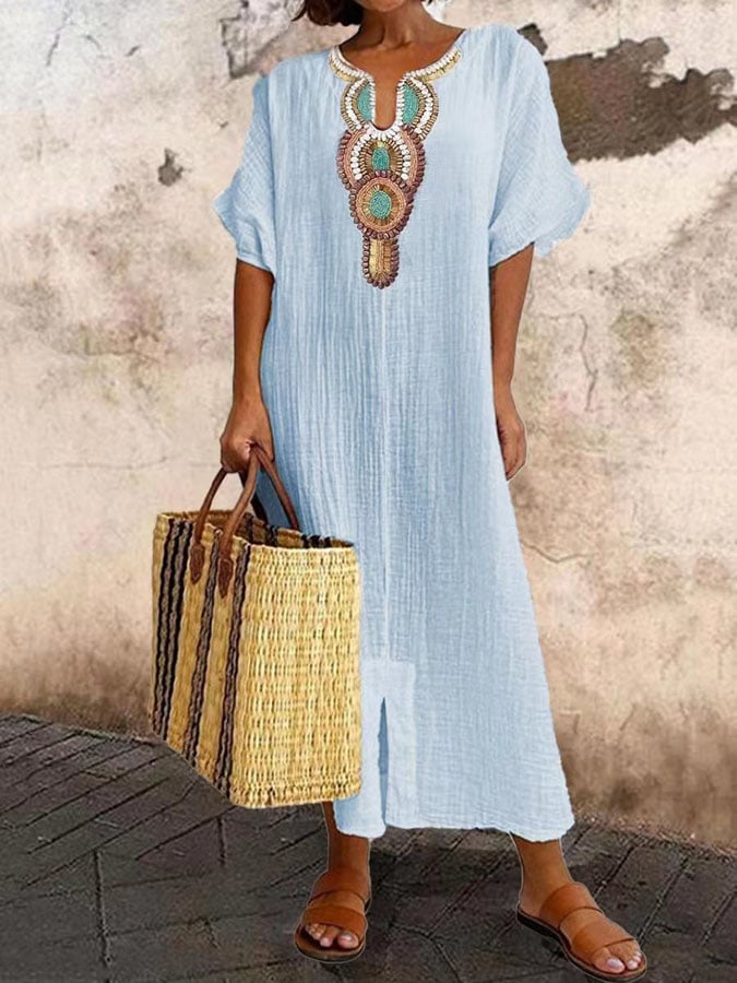 Vrolijke dame draagt comfortabele geborduurde maxi kaftan zomerjurk op het strand.