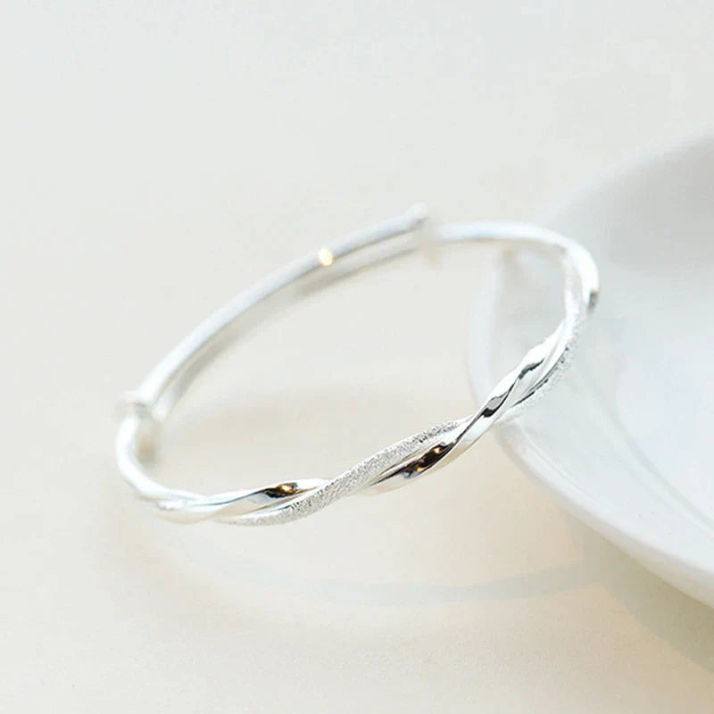 Stijlvolle dames zilveren gedraaide armband gedragen om een pols, perfect voor dagelijks gebruik of feestjes