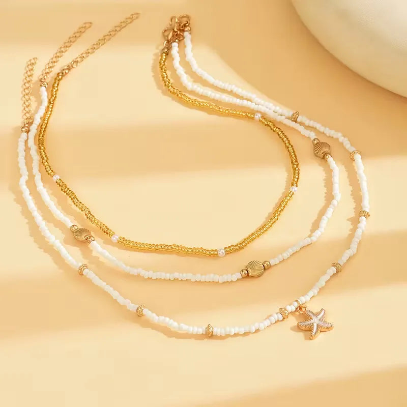 Elegante schelpketting voor dames met fijne zeesterhanger en subtiele gouden accenten.