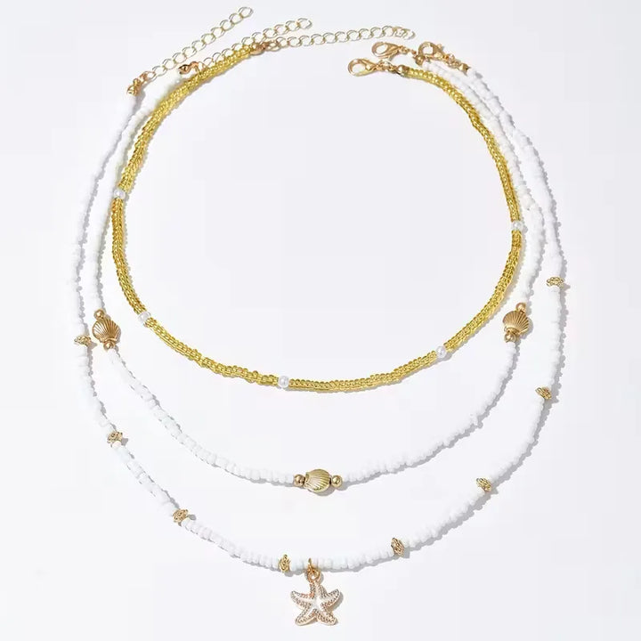 Minimalistische dames schelpketting met zeesterbedel, witte kralen; stijlvolle zomerse sieraden.