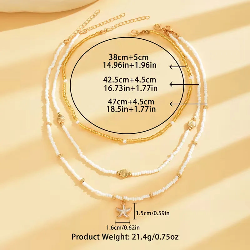 Gelaagde damesketting met schelp, zeester en parels; stijlvol voor de zomer en strand.