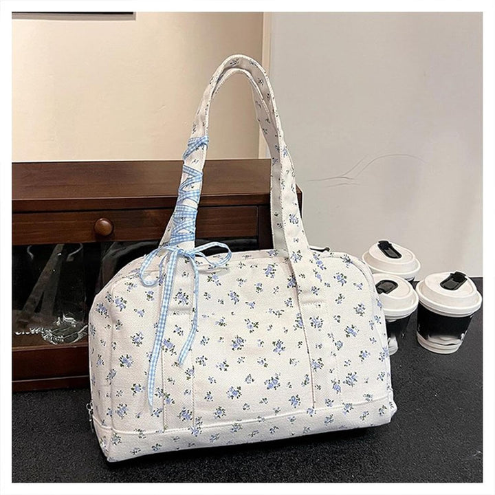 Blauwe canvas schoudertas voor dames, grote weekendtas met elegant striklint, perfect voor weekendtrips.
