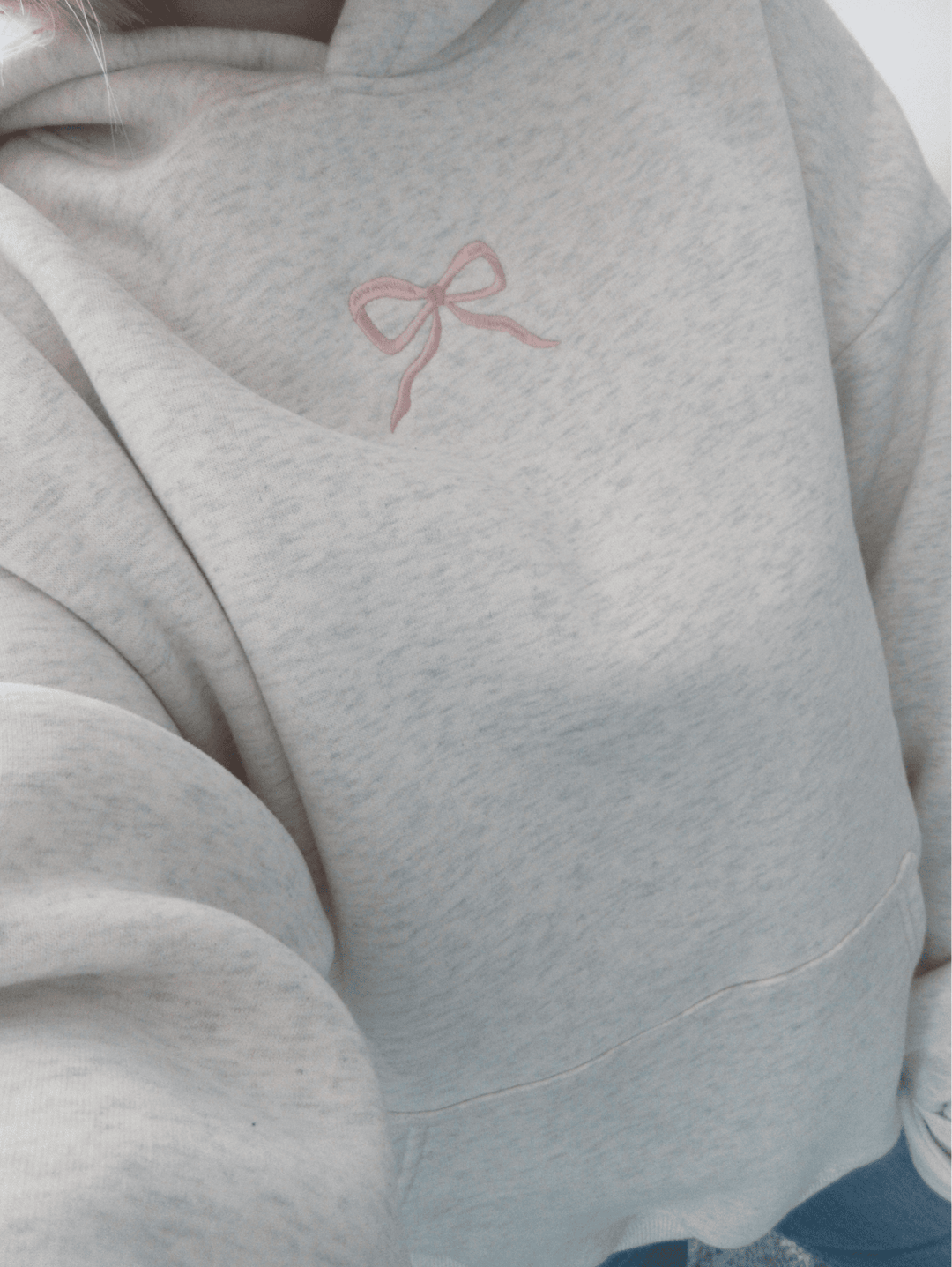 Detail van de stijlvolle roze strik op de rug van een comfortabele dames hoodie, voor een trendy look.