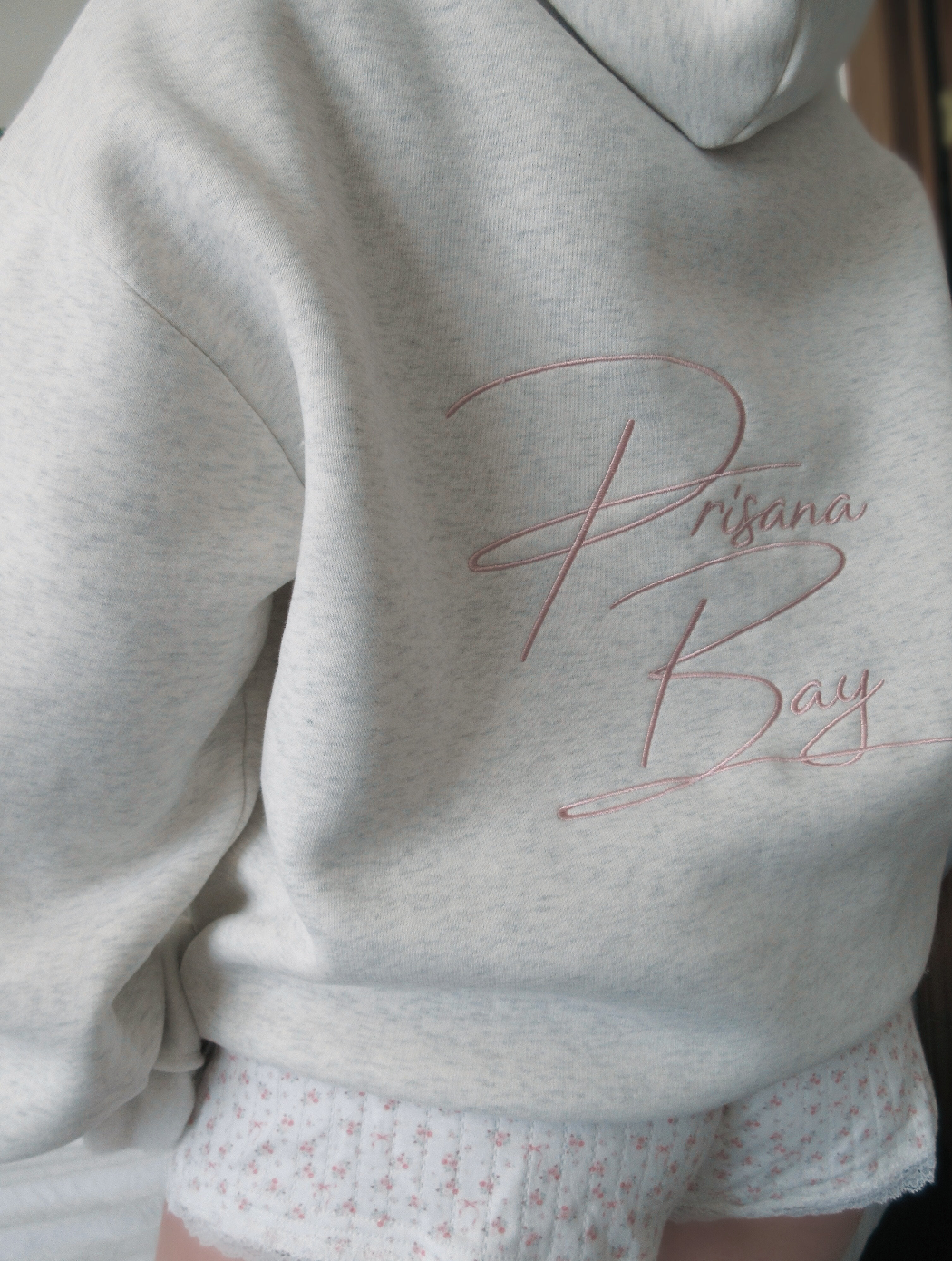 Stijlvolle dames hoodie met roze strik, gedragen voor een casual en comfortabele alledaagse look.