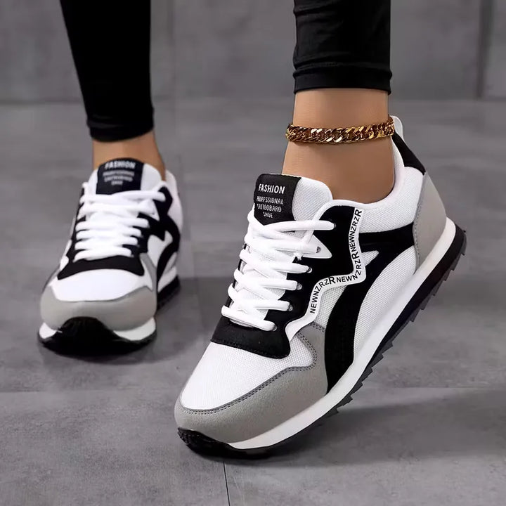 Stijlvolle witte dames lage sneakers met opvallende sportieve zijstrepen, veters en een comfortabele pasvorm.