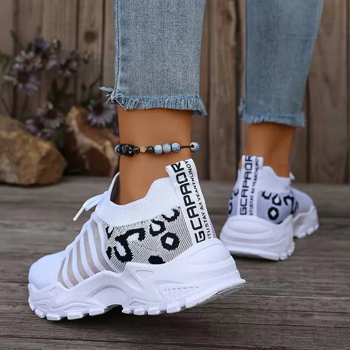 Witte dames lage sneakers met trendy luipaardprint, chunky zool en zwarte accenten voor een casual look.