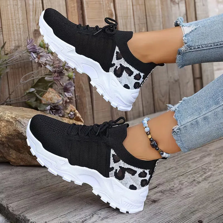 Dames lage sneakers van bovenaf, trendy luipaardprint en dikke witte zool, klaar voor de lente mode.