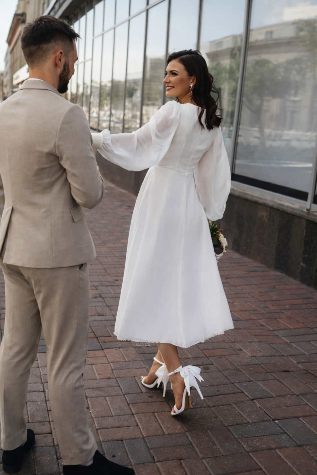 Trendy witte dameskleding jurk met V-hals en elegante pofmouwen. Lange mouwen voor een feestelijke look.