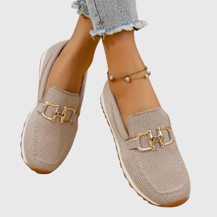 Zwarte dames loafers met plateauzool en gouden gesp, zij-aanzicht toont dikke zool.