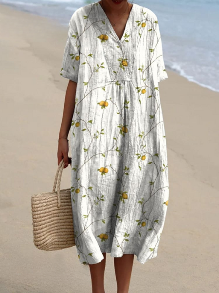 Zijaanzicht van de flowy dames midi jurk met bloemenprint. V-hals en korte mouwen, comfortabel voor de zomer.