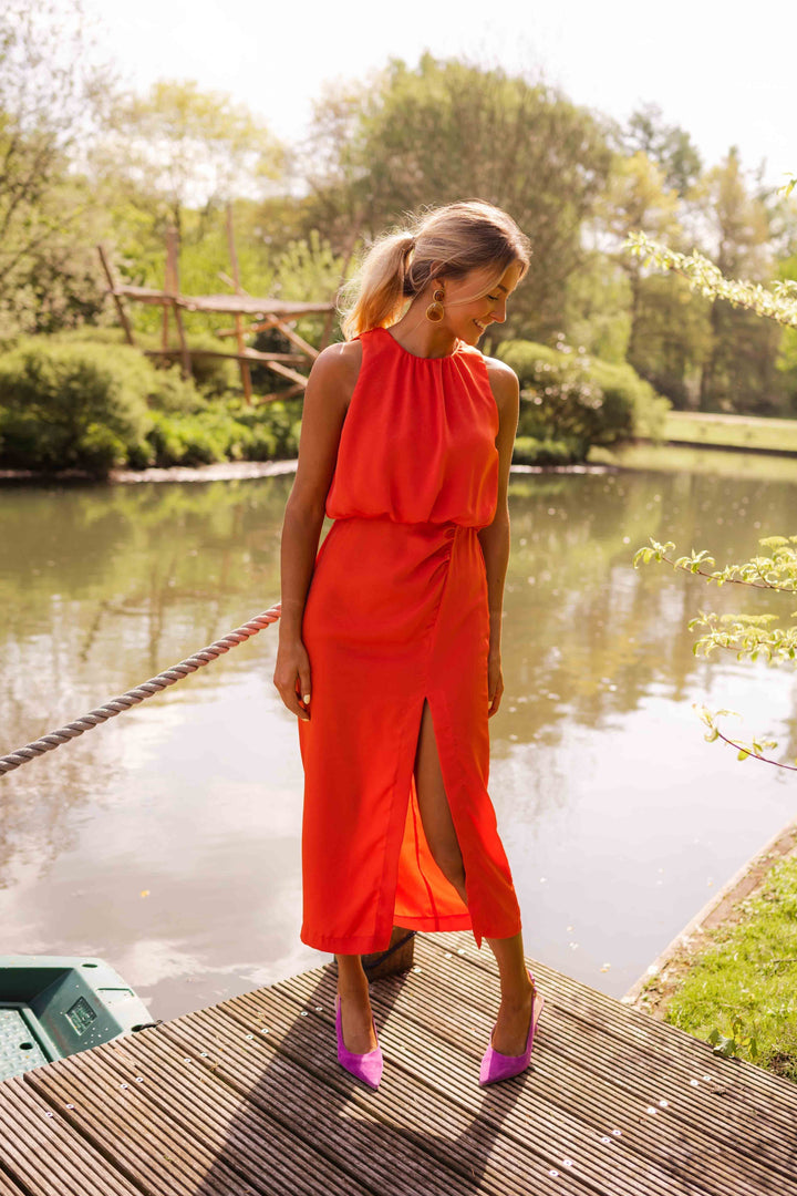 Vrouwelijke gele feestjurk, getailleerd en mouwloos, met elegante halskraag en hoge split.
