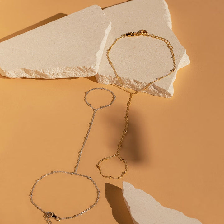 Zilverkleurige minimalistische handketting en ring sieraad voor dames, een moderne mode accessoire.