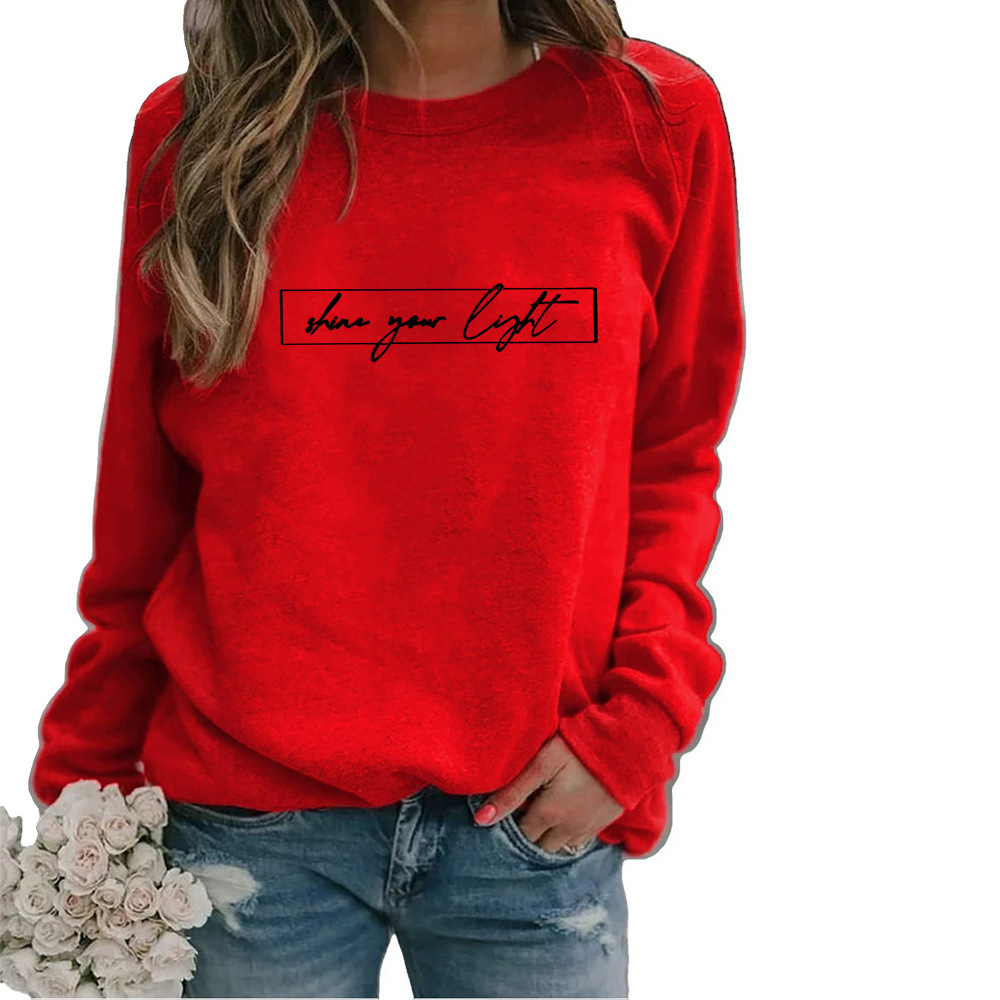 Casual mode: vrouw in oversized slogan sweatshirt gecombineerd met jeans voor trendy stijl.