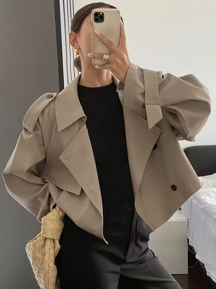 Achteraanzicht van de oversized dames trenchcoat, casual en comfortabel silhouet.