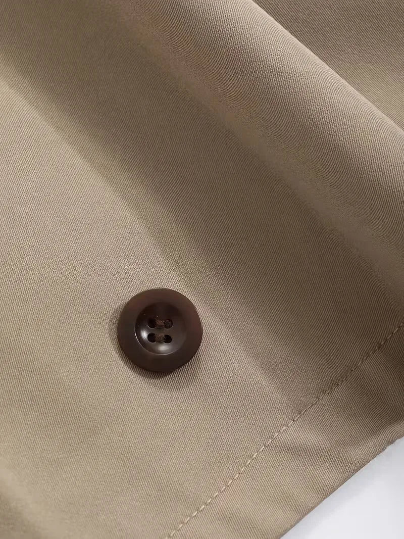 Zijprofiel van een oversized dames trenchcoat, vloeiende lijnen, moderne pasvorm.