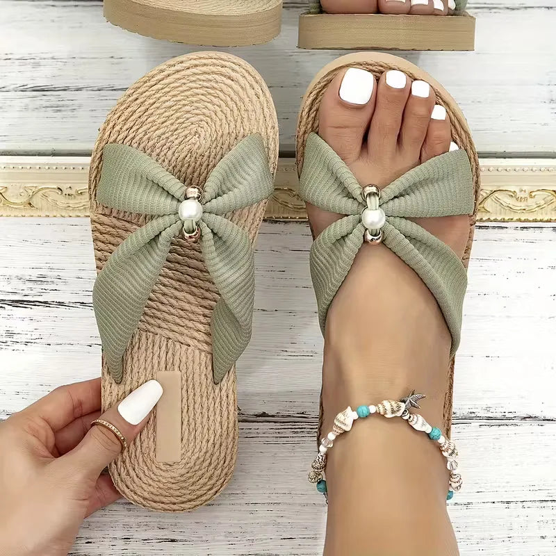 Comfortabele open teen sandaal voor dames, plat en bohemian, met strik en kralen accenten.