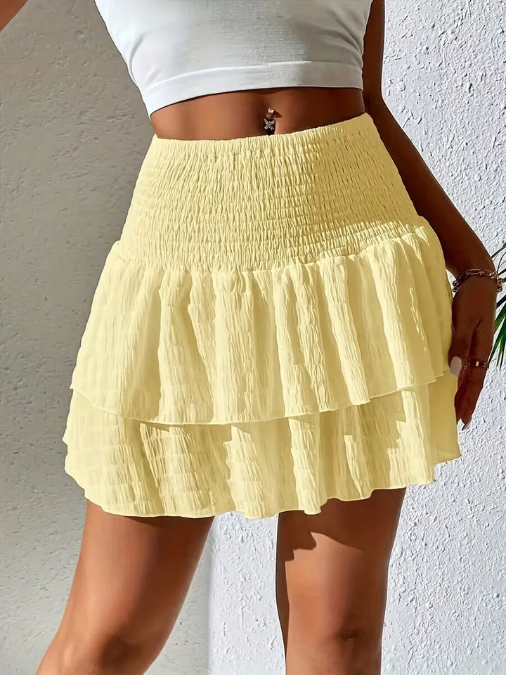 Casual dames plooirok met gesmokte details en zwierige flounce, perfect voor warme dagen.